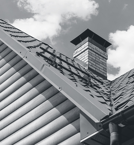 Chimney on the roof of the house against the blue sky