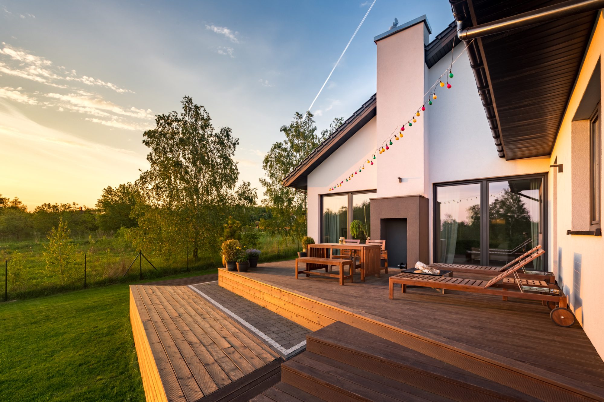 Modern house with patio and functional outdoor furniture, during sunset