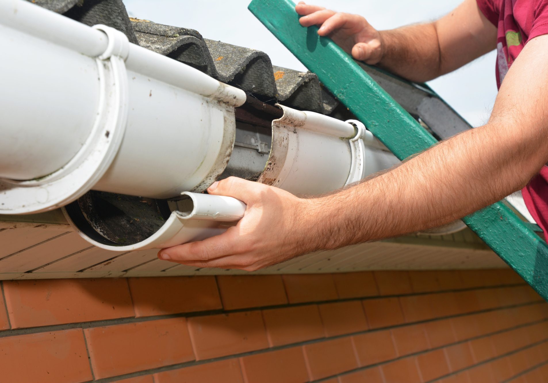 Guttering repair. Roofer contractor repair rain gutter. Close up.