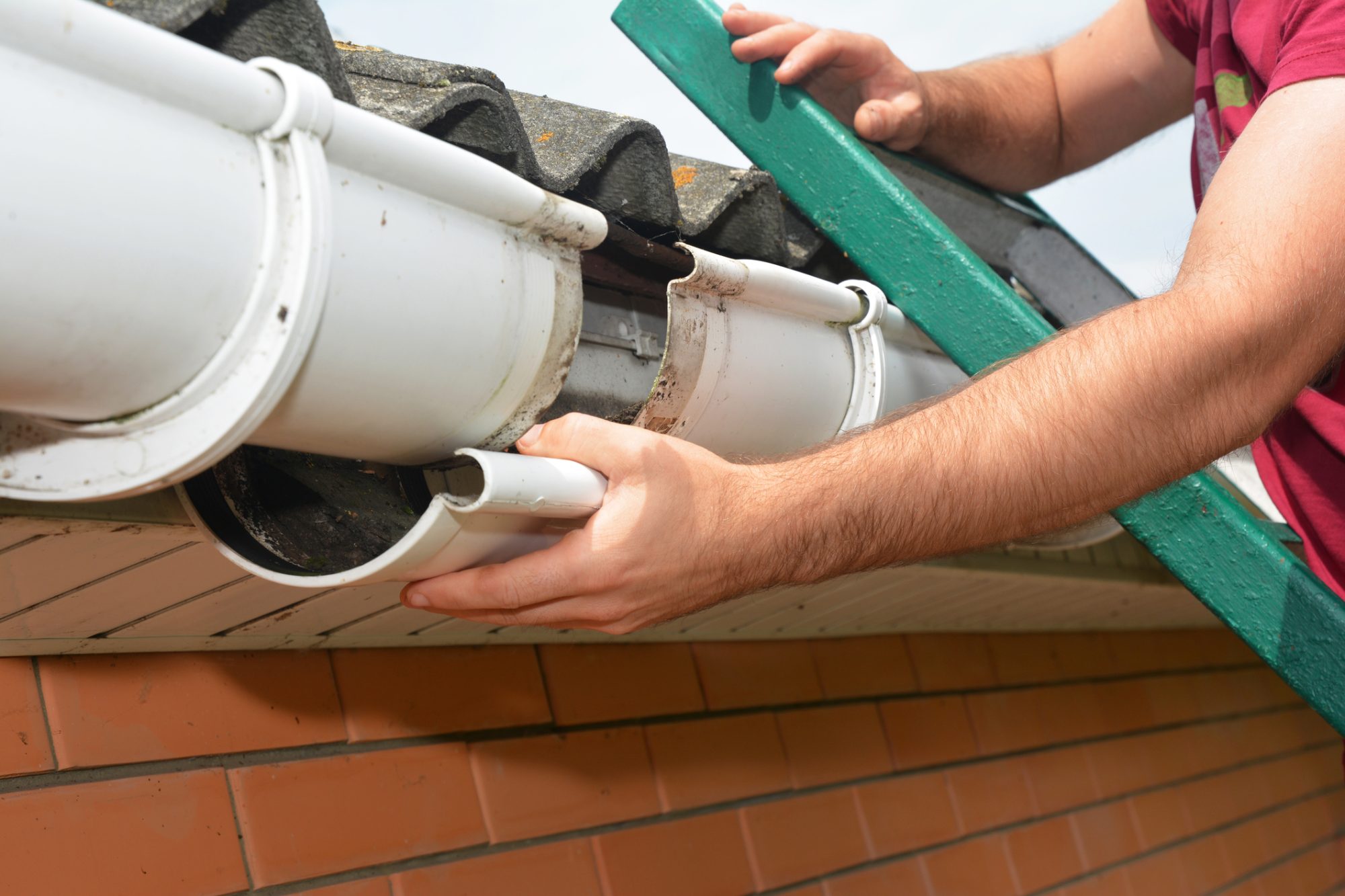 Guttering repair. Roofer contractor repair rain gutter. Close up.